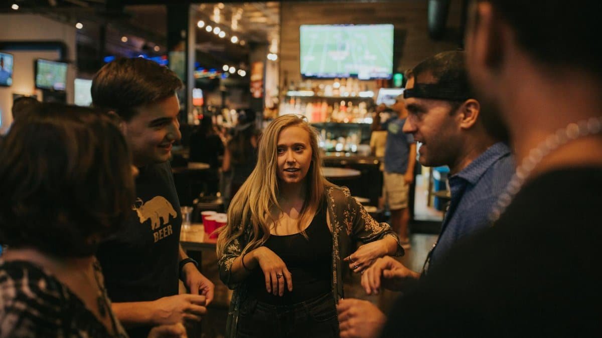 Group of friends enjoying a night out at a bar in Denver, sharing laughs and conversation.