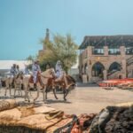 Vibrant marketplace in Doha with traditional textiles and riders on horses. Captures Qatari culture.