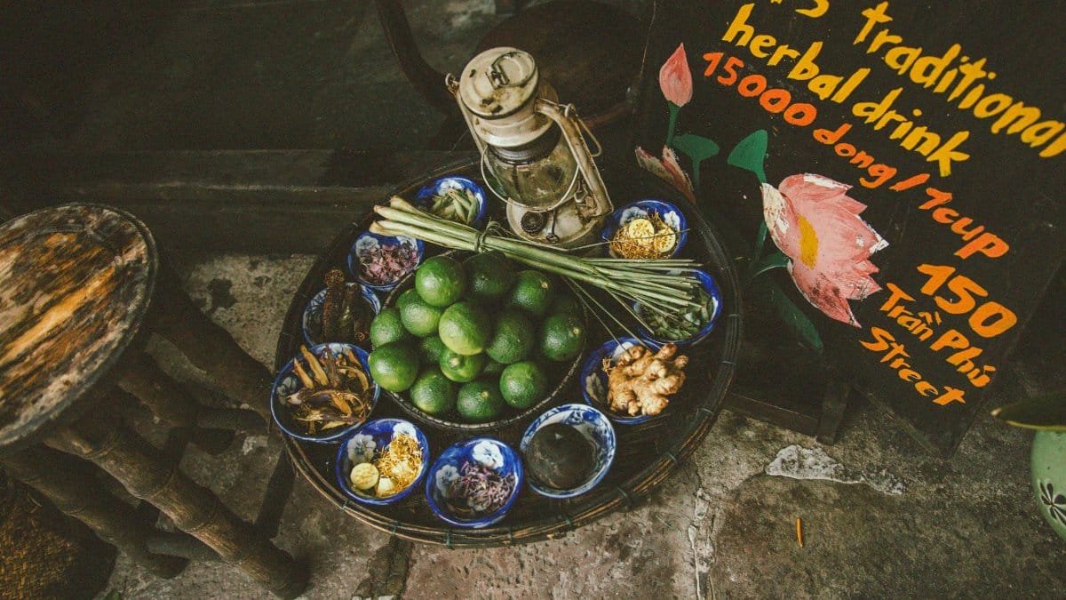 An overhead view of traditional herbal drink ingredients displayed on a street table, capturing vibrant textures and colors.