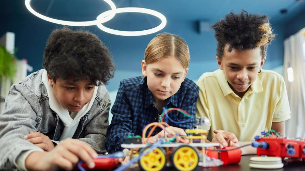 Young students focus on building a robotics project together, showcasing teamwork and creativity.