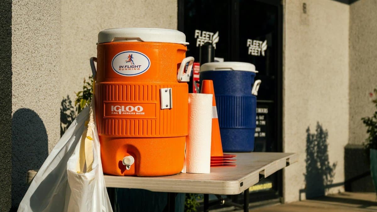 Bright outdoor scene with orange and blue water coolers at Fleet Feet store in Houston, TX.