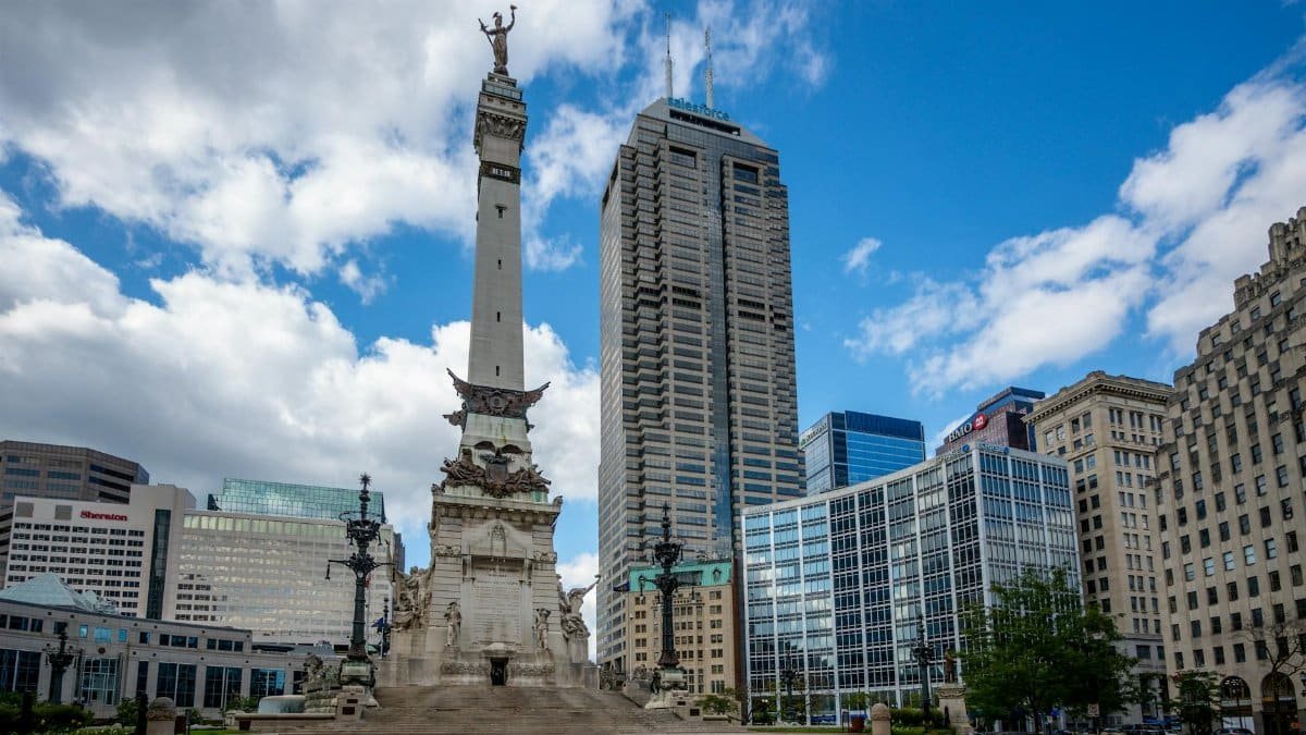 View of the Soldiers and Sailors Monument with Indianapolis skyline under a clear blue sky.