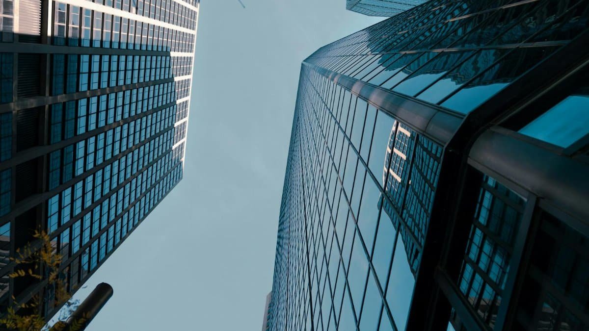 Urban skyscrapers in Philadelphia reflect the sky in a dramatic low-angle view.