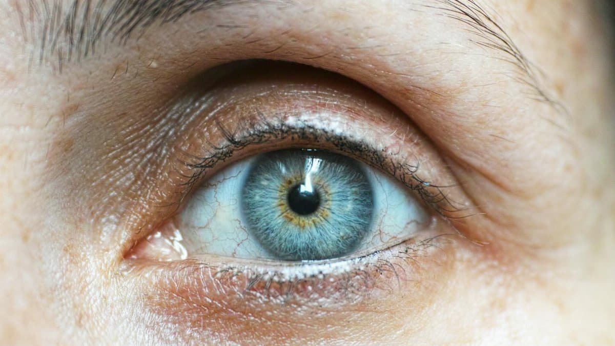 Detailed close-up image of a woman's blue eye revealing intricate details.