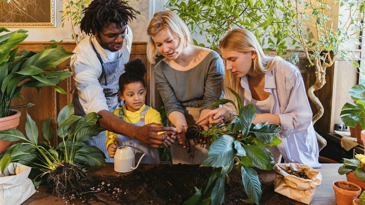 Diverse family gardening indoors, nurturing plants together, enhancing growth.