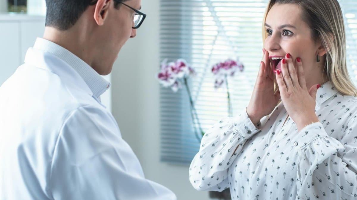 Woman surprised by results in a medical consultation with doctor measuring her waist.