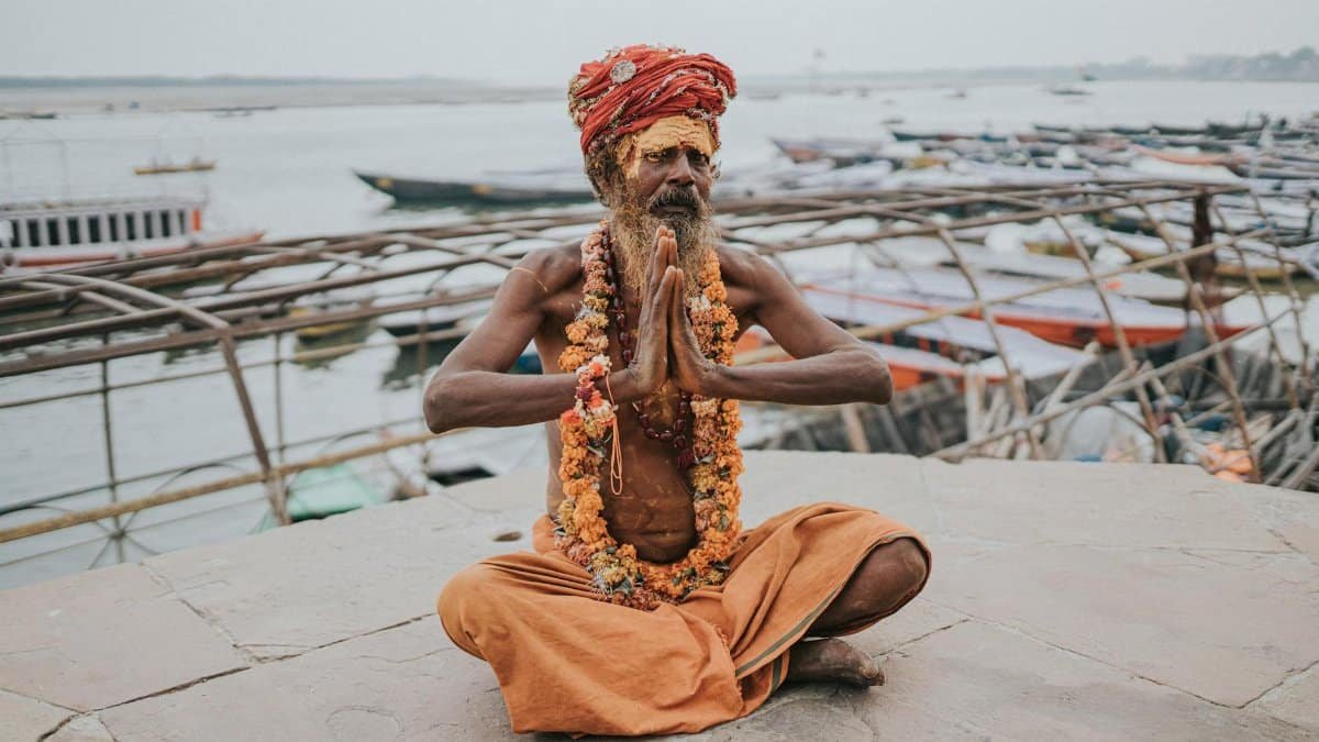 A spiritual Sadhu meditating by the Ganges River in Varanasi, India. Captivating cultural scene.