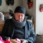 An elderly shoemaker in Kahramanmaraş, Türkiye, crafting shoes in his workshop surrounded by materials.