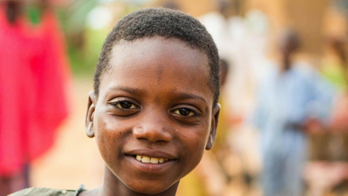 Portrait of a smiling child outdoors with a warm and vibrant background, capturing joy and innocence.