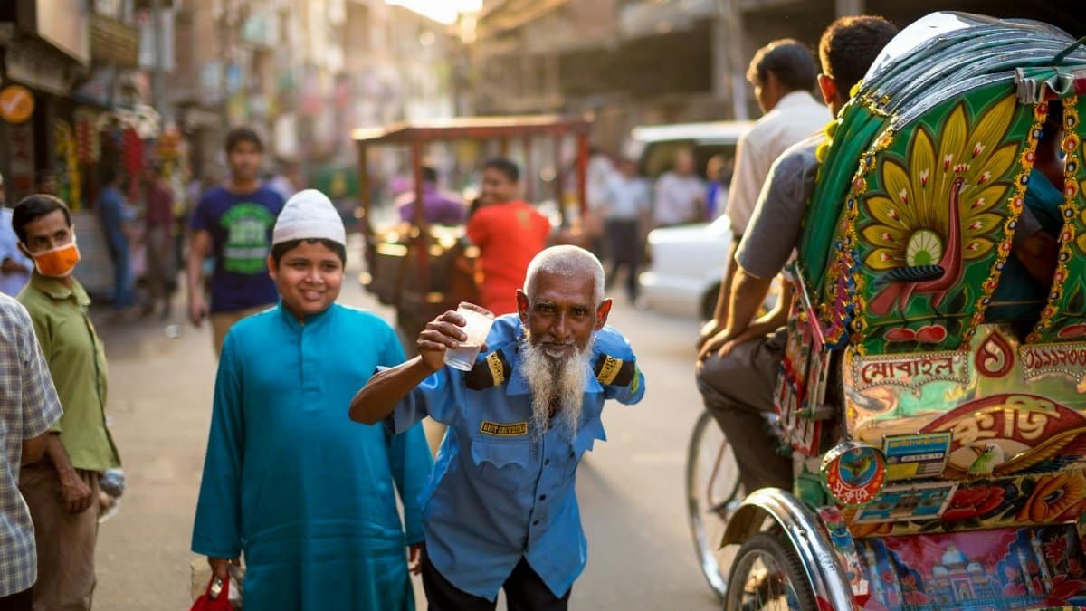 A lively street in Bangladesh with people, colorful rickshaws, and a friendly atmosphere.