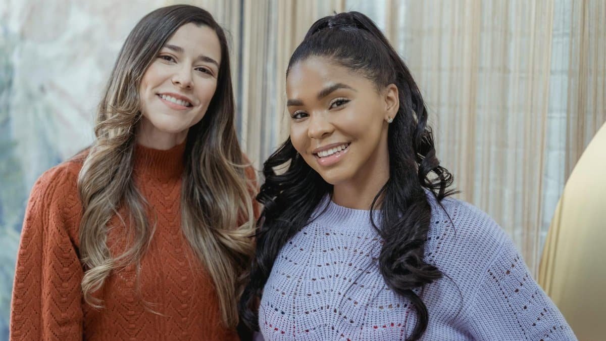 Diverse women with long hair in woolen stylish casual sweaters smiling and looking at camera