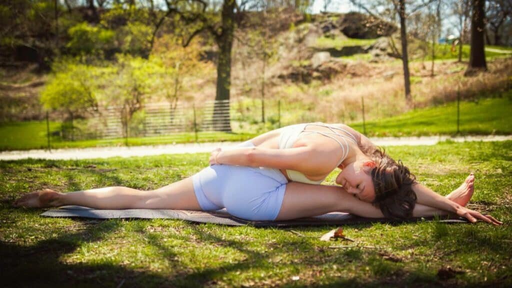 Woman practicing yoga in Central Park, New York, USA in a peaceful spring outdoor setting.