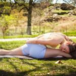 Woman practicing yoga in Central Park, New York, USA in a peaceful spring outdoor setting.