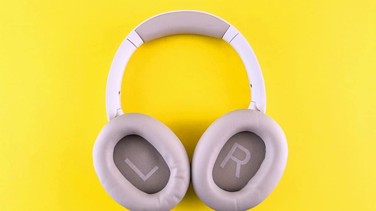 Stylish wireless headphones placed on a bold yellow surface, showcasing modern design and comfort.