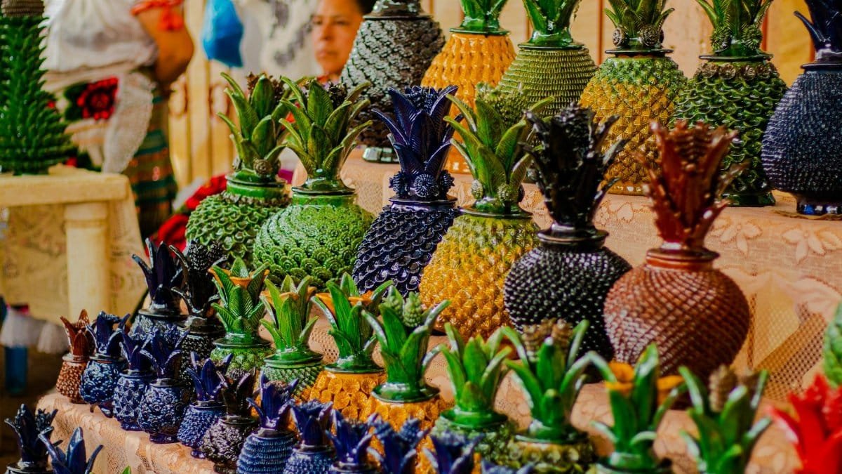 Colorful handcrafted pineapple-shaped pottery on display in Michoacán, Mexico's vibrant market.