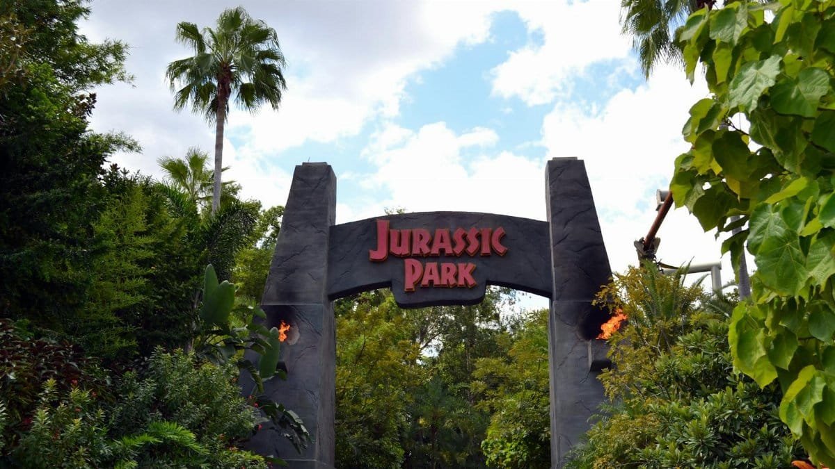 A lush, iconic Jurassic Park entrance in Orlando's Universal Studios.