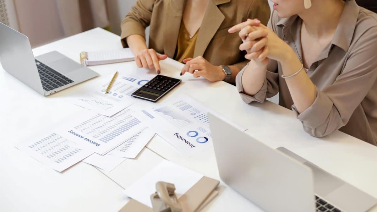 Two professionals collaborating on financial documents in a modern office setting.