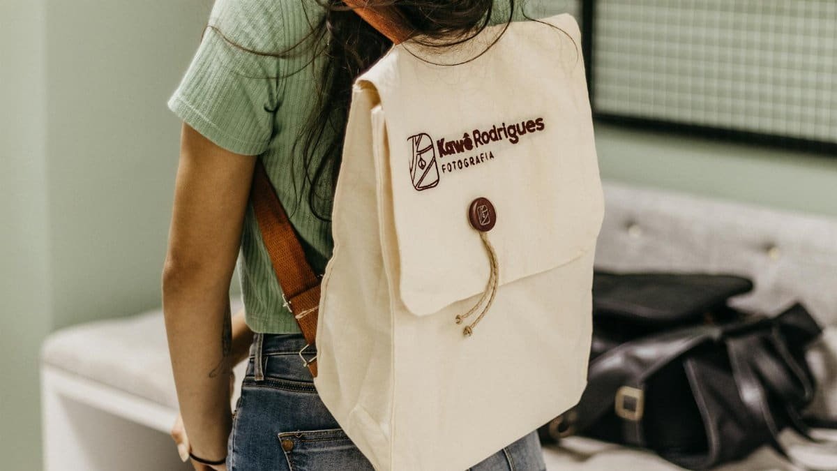 Woman with a beige backpack in a casual setting, showcasing everyday fashion style.