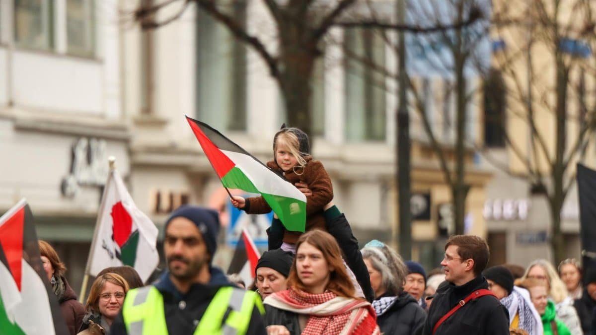 Crowd in Gothenburg demonstrating with flags for freedom and peace on a city street.