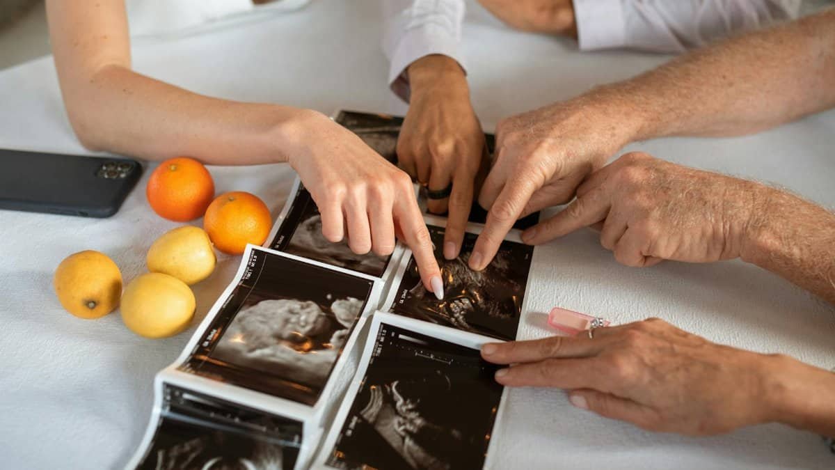 Family members gathered around ultrasound scans, joyful and supportive during pregnancy announcement.