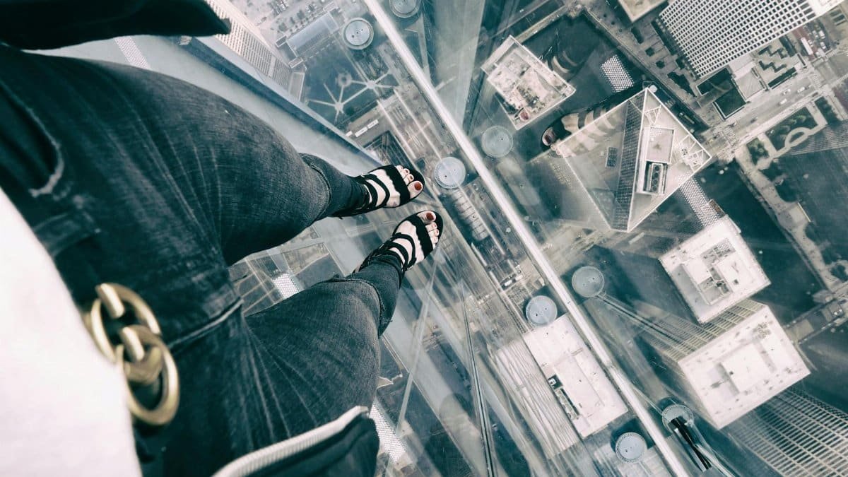 View from a glass platform showcasing skyscraper rooftops in Chicago from above.