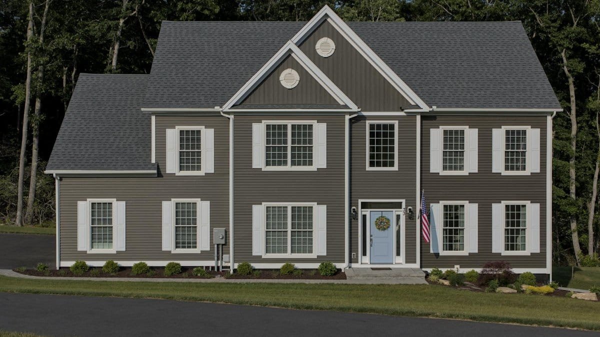 Front view of a classic suburban American house with manicured lawn and driveway.
