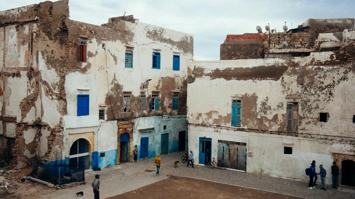Rustic buildings with blue doors in Essaouira, Morocco highlight cultural charm.