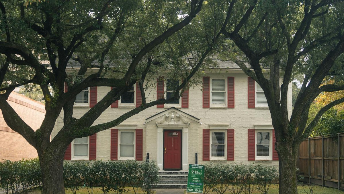 Classic colonial house with red shutters and trees in Houston, Texas, available for lease.