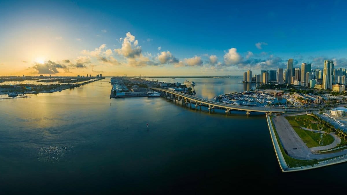Aerial view of the Miami skyline with sunrise reflecting on the ocean.