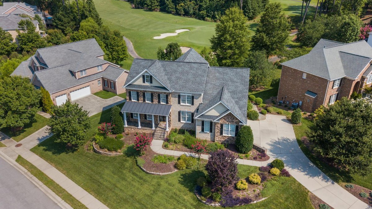 Aerial view showcasing a suburban home adjacent to a lush golf course in Raleigh, NC.