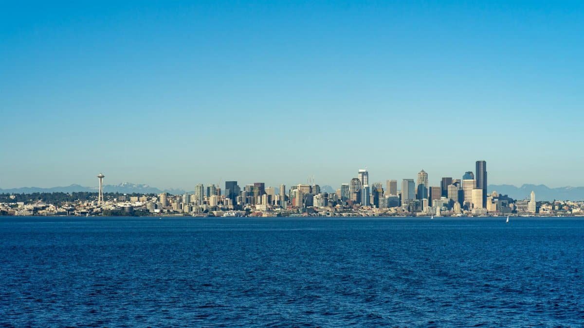 Stunning panoramic view of the Seattle skyline across the water under a clear blue sky.