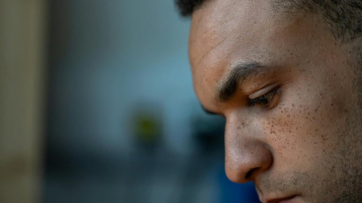 Close-up portrait of a man deep in thought, showcasing focus and concentration indoors.