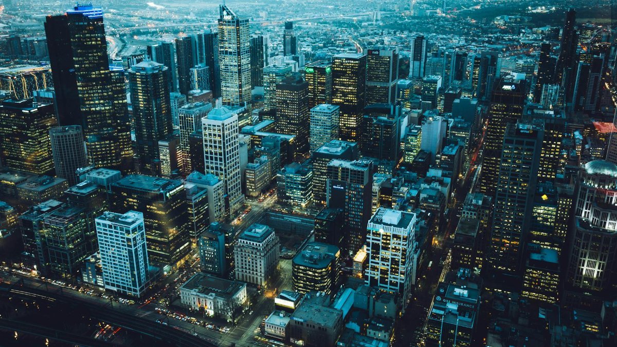 Captivating aerial view of a bustling city skyline at night with illuminated skyscrapers.