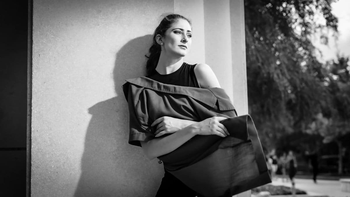A stylish black and white portrait of a woman leaning against a wall in Orlando.