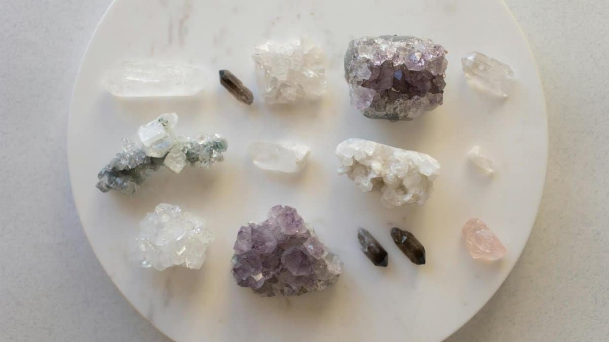 A top view of various healing crystals on a marble surface, showcasing natural beauty.