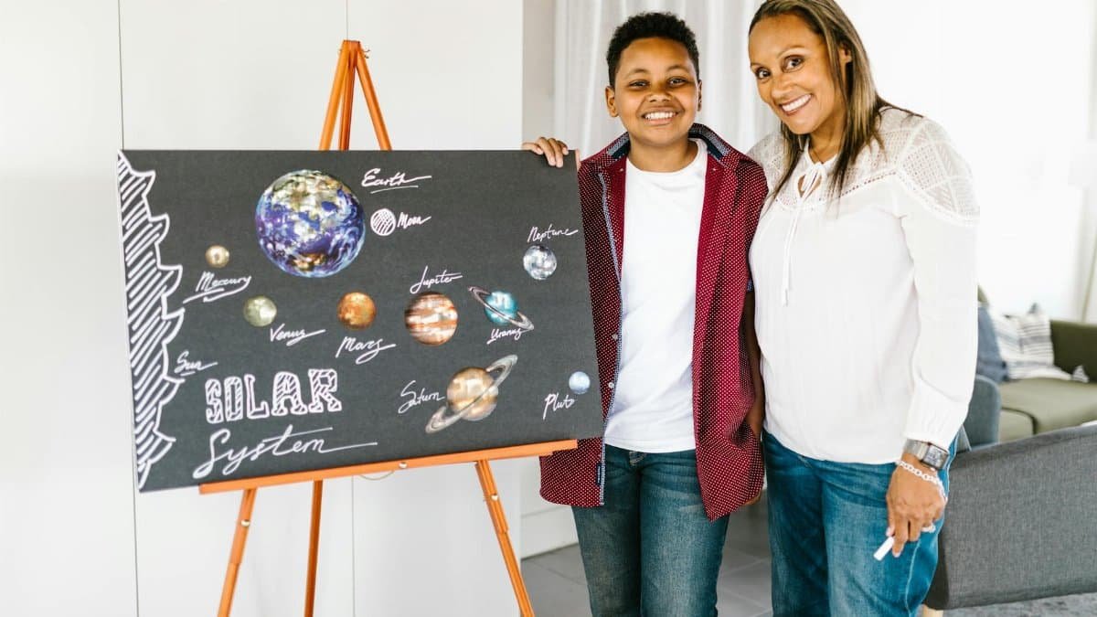 Mother and son proudly present a homemade solar system project for school.