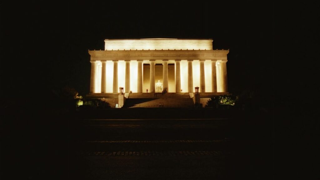 The Lincoln Memorial beautifully lit against a dark sky, showcasing its iconic pillars in Washington, DC.