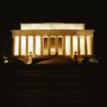 The Lincoln Memorial beautifully lit against a dark sky, showcasing its iconic pillars in Washington, DC.