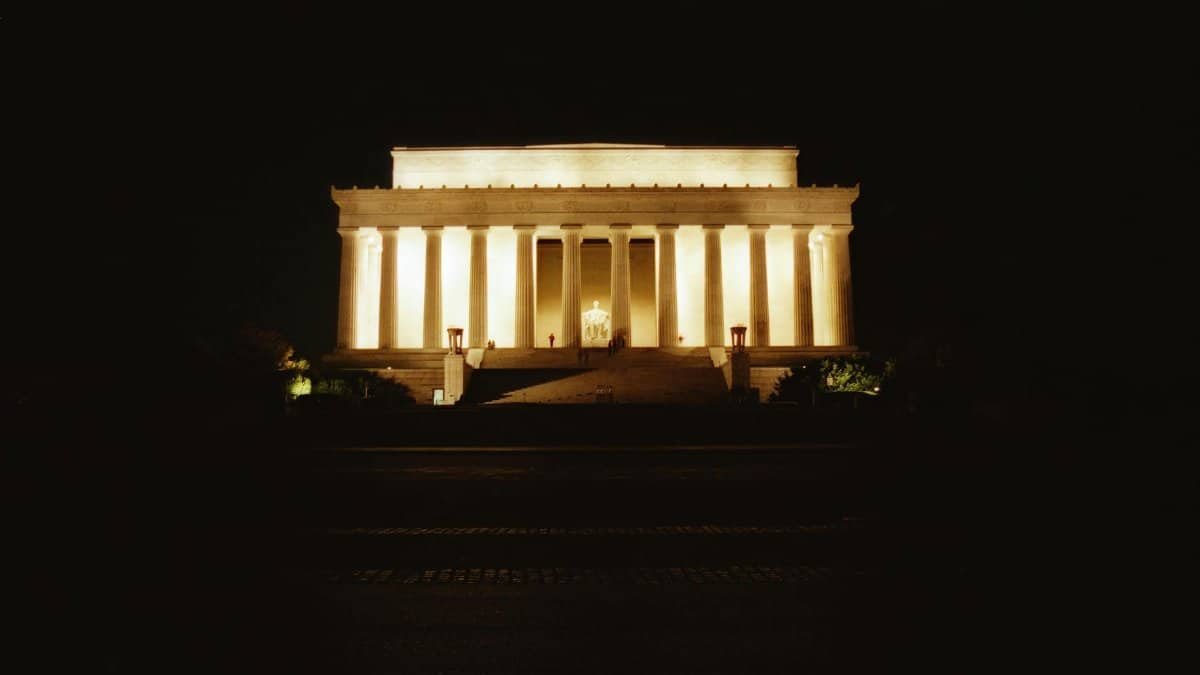 The Lincoln Memorial beautifully lit against a dark sky, showcasing its iconic pillars in Washington, DC.