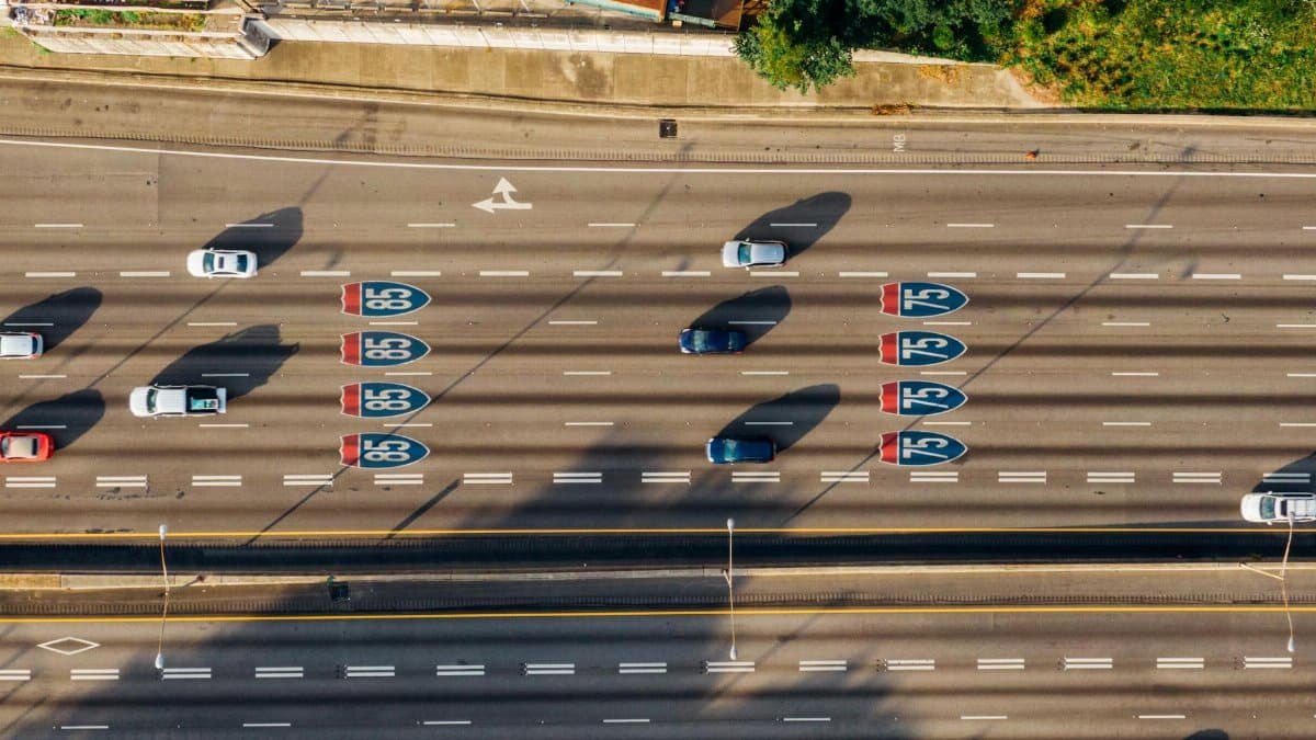 Overhead view of cars on Atlanta's I-85 and I-75 highways on a sunny day.
