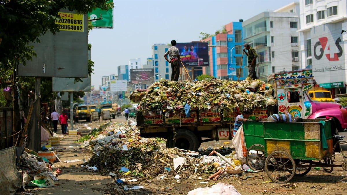 Trash-filled streets with vibrant urban buildings in Bangladesh.
