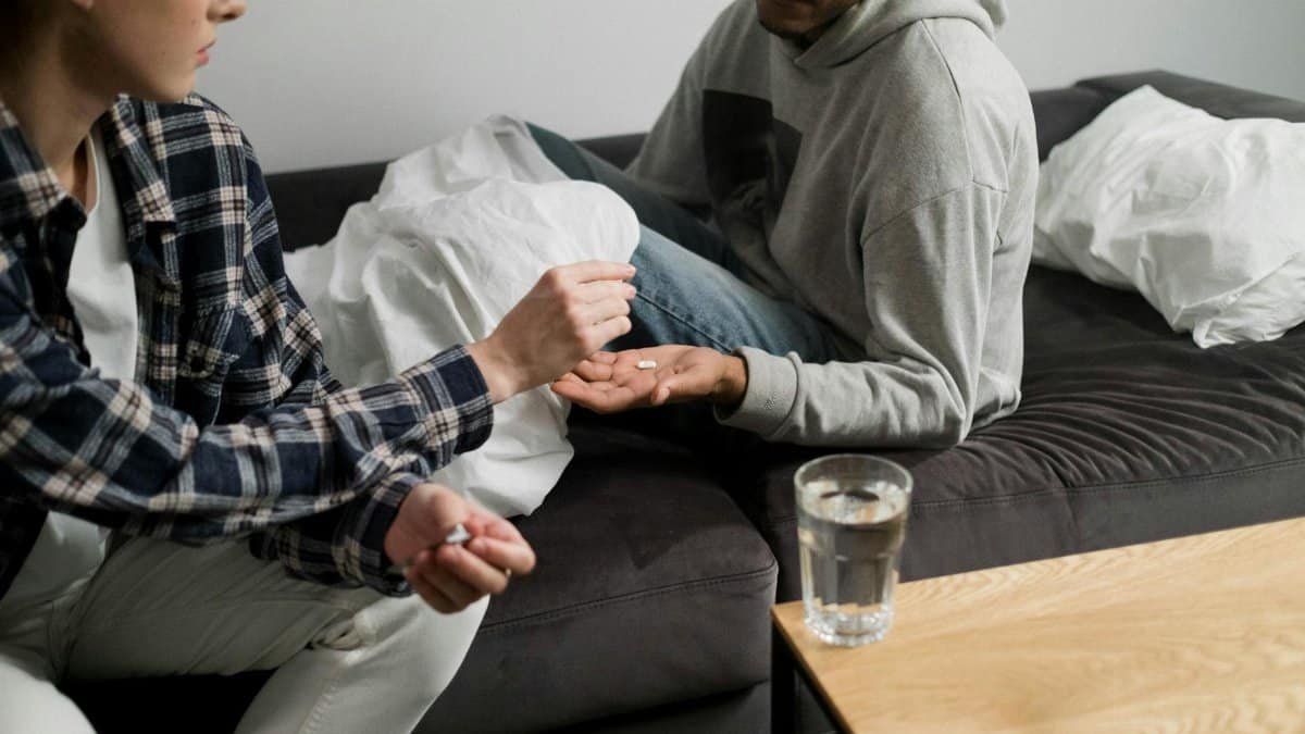 A couple sitting on a sofa with medication, emphasizing mental health support.