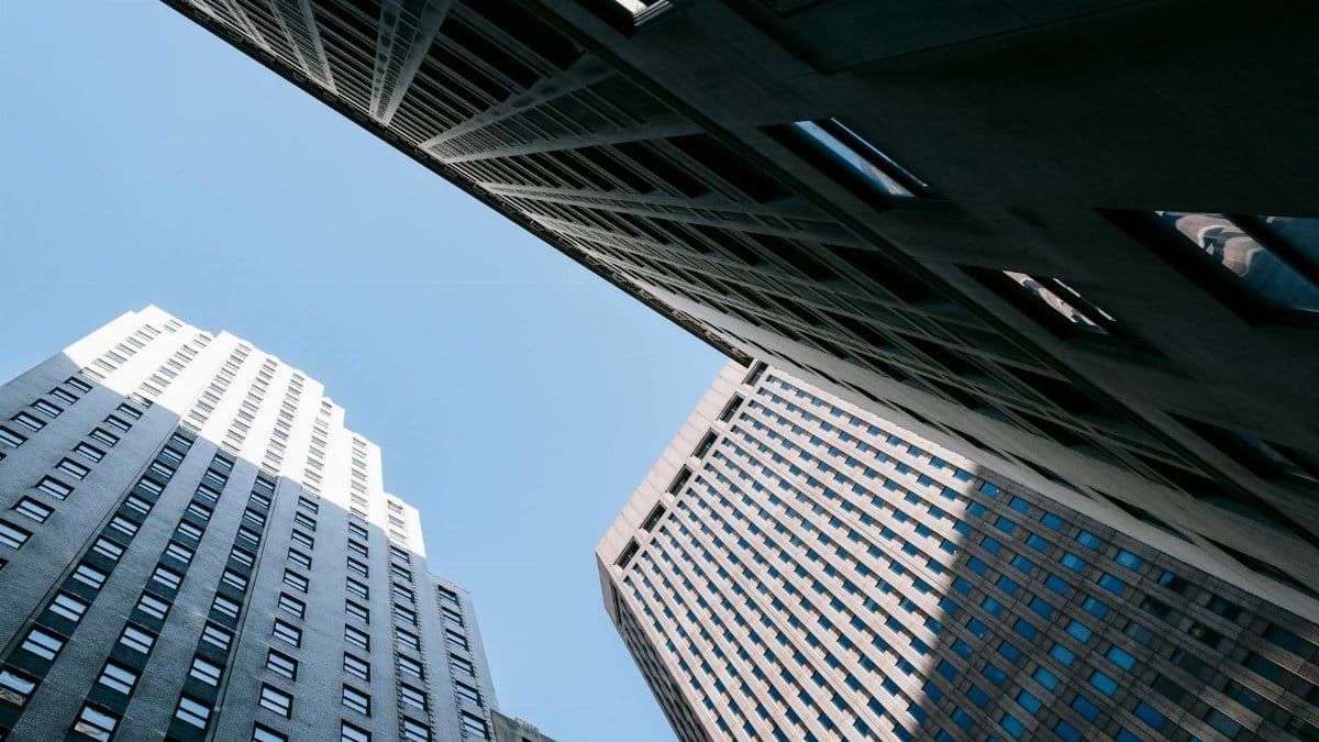 From below of contemporary high multistory office skyscrapers located in downtown against blue sky