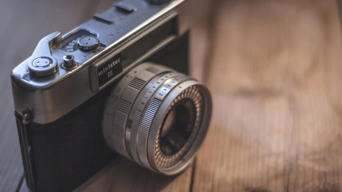 Classic vintage camera on wooden surface, highlighting retro design in soft focus.