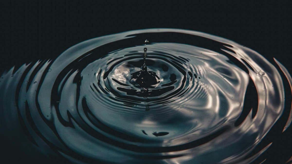 Captivating water droplet causing ripples, illustrating calmness and reflection.