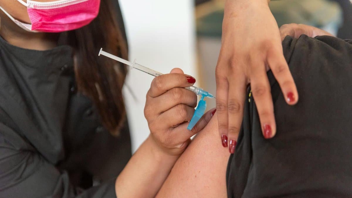 Close-up of a healthcare worker giving a vaccination shot to a patient indoors.