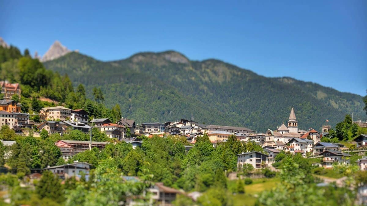 Picturesque mountainside village with lush greenery and scenic views in summer.