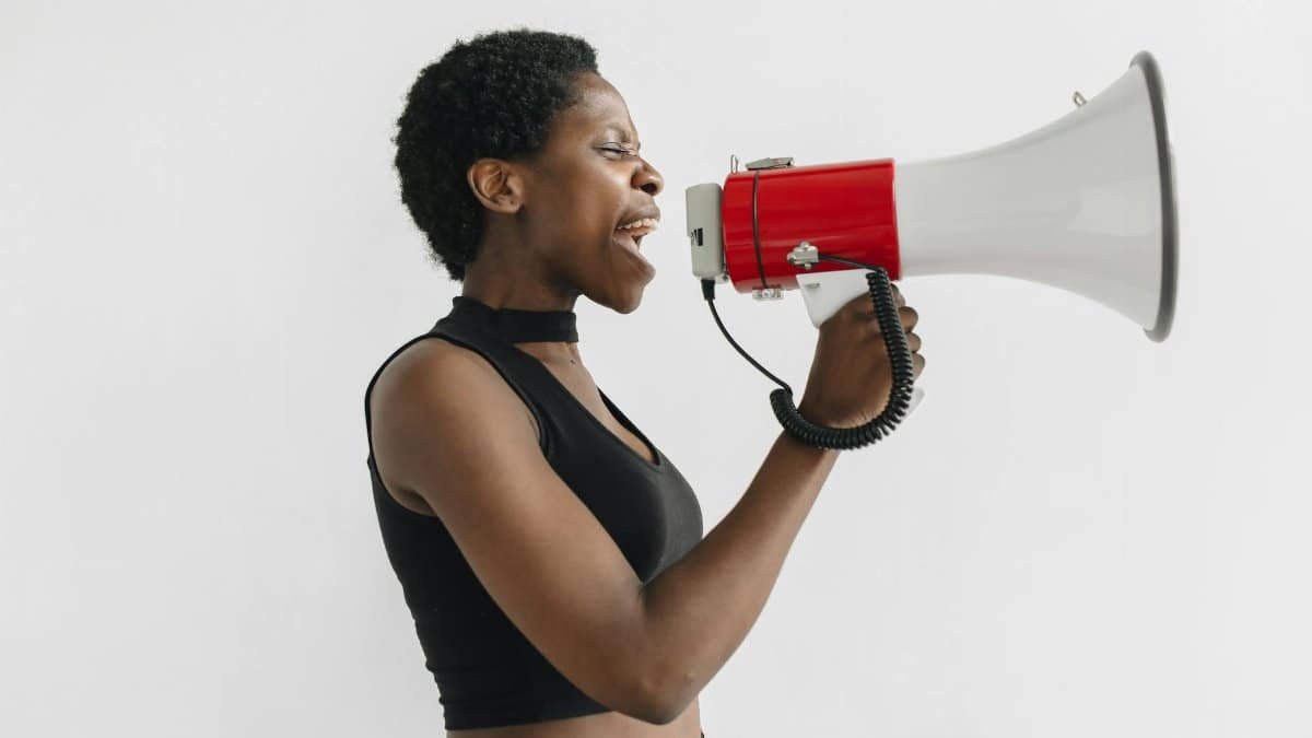 African American woman using a megaphone to protest, symbolizing activism and empowerment.