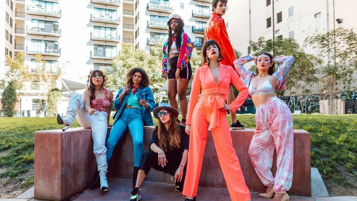 A fashion-forward diverse group showcasing vibrant street style in a city backdrop.
