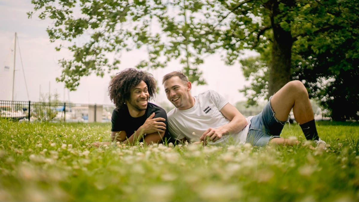 Two men enjoying a sunny day at a Chicago park, portraying love and relaxation.